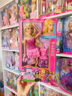 a barbie doll in a pink dress is on display at a toy store with other barbie dolls