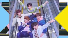 group of young men riding an escalator with their arms up in the air