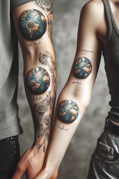 two people holding hands with tattoos on their arms and one has the earth in it