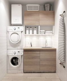 a washer, dryer and cabinets in a small room with tile flooring