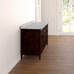 an empty room with white walls and wood flooring is pictured in this image, there is a marble top vanity on the left side of the cabinet