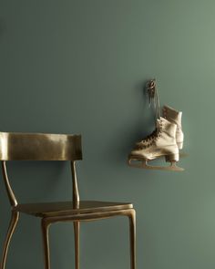 a pair of ice skates hanging on the wall next to a chair