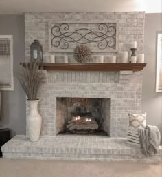 a living room with a fire place in the center and candles on top of it