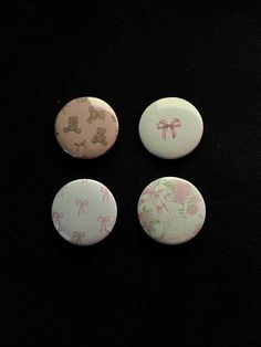 three buttons with bows on them sitting on a black surface