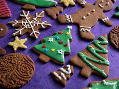 many decorated cookies are on a purple surface