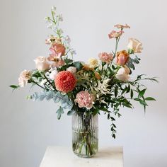 a vase filled with lots of flowers on top of a table