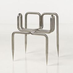 three metal objects sitting on top of each other in the middle of a white floor