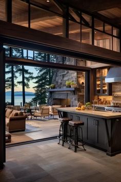 an open kitchen and living room area with large glass doors leading out to the water