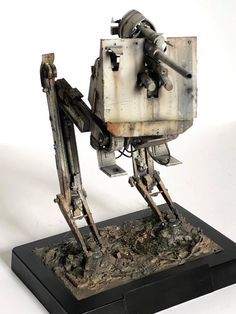 an old robot made out of metal on a black base and white backgroud