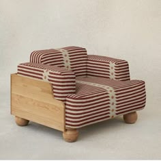 a red and white striped chair sitting on top of a wooden frame