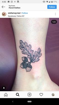 a small tattoo on the ankle of a woman with acornatio and leaves