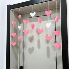 a shadow box with hearts hanging from it