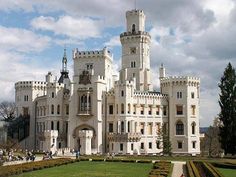 a large white castle sitting on top of a lush green field