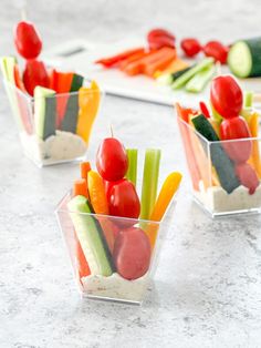 four small cups filled with different types of veggies on top of a table