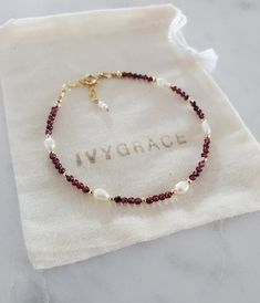 Delicate beaded gemstone bracelet made with tiny dark red, 2mm round garnet beads, freshwater pearls and 2mm round gold-filled beads.   The bracelet is finished with a 14ct gold-filled clasp and extension chain which allows a length between 17-19cm.  Perfect if gifting. ☆ 14ct gold-filled is a high quality, affordable alternative to solid gold.  It consists of a thick layer of gold which is mechanically bonded to the base metal.  With minimal care, gold-filled jewellery can last for years and wi Burgundy Beaded Bracelets, Handmade Gold Bracelet, Red Bracelet Ideas, Gemstone Bracelets Ideas, Bracelet Ideas Beads, Wire Bead Bracelet, Diy Earrings Dangle, Tiny Bead Bracelet, Garnet Bead Bracelet