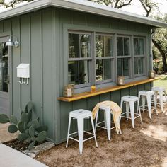 an outdoor bar with stools and tables in front of it