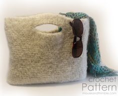 a pair of sunglasses sitting on top of a white bag next to a blue and green scarf