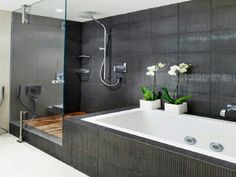 a bathroom with a large bathtub next to a walk in shower and two flower vases on the counter