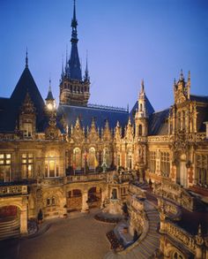 an ornate building with lots of windows and lights on it's sides at night