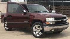 a maroon pick up truck parked in a parking lot