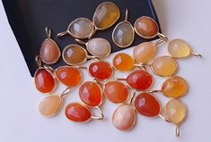 a bunch of different colored stones sitting on top of a white table next to a black bag