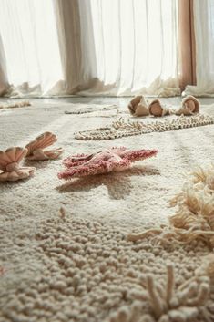 several seashells are scattered on the floor in front of curtains and drapes