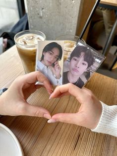 a person holding up two photos in front of their face and heart shape with the other hand