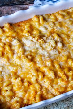 a casserole dish with macaroni and cheese in it on a wooden table