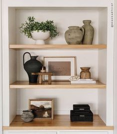 some shelves with vases and pictures on them