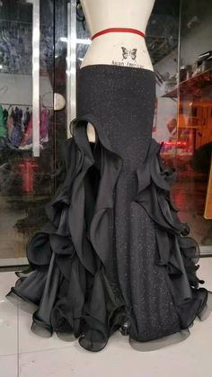 a mannequin wearing a black dress with ruffles on it's skirt