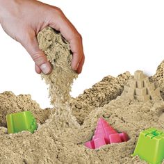 a hand is sprinkling sand with colored blocks