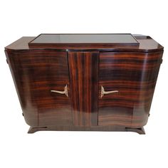 an art deco cabinet with glass doors and handles on the front, inlaid with brass hardware