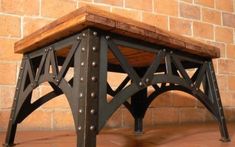 a wooden bench sitting in front of a brick wall with rivets on it