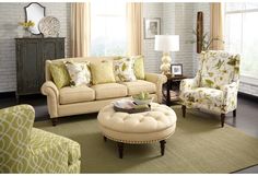 a living room filled with lots of furniture and pillows on top of a green rug