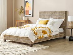 a bed with white sheets and yellow pillows