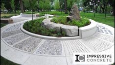 a circular garden with rocks and plants in the center, surrounded by concrete pavers