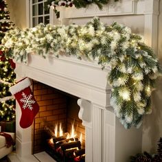 a fireplace decorated with christmas garland and stockings