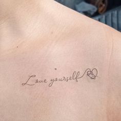 a woman's back with the words love yourself tattooed on her left side ribcage