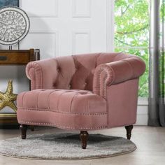 a pink chair sitting on top of a rug