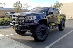 a large black truck parked in a parking lot