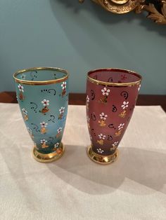 two colorful vases sitting on top of a table