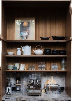 the shelves are filled with dishes, cups and other kitchen utensils on them