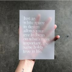 someone holding up a piece of paper that says just as white space in design allows your eye to focus on what's most important, the same holds true in life