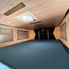 an empty room with blue carpet and wooden walls