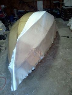 a boat covered with white cloth in a garage