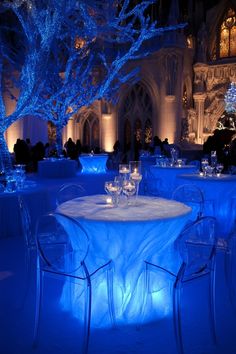 the tables are lit up with blue lights for an elegant dinner or banquet event at night