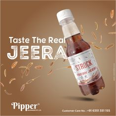 a bottle of beer with some grain flying around it and the caption reads, taste the real jeera