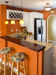 a kitchen with white cabinets and an island in front of the sink is painted orange