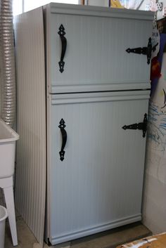 a white refrigerator freezer sitting inside of a kitchen next to a bucket and trash can