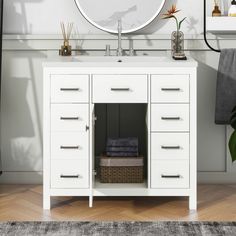 a bathroom vanity with drawers and a mirror above it